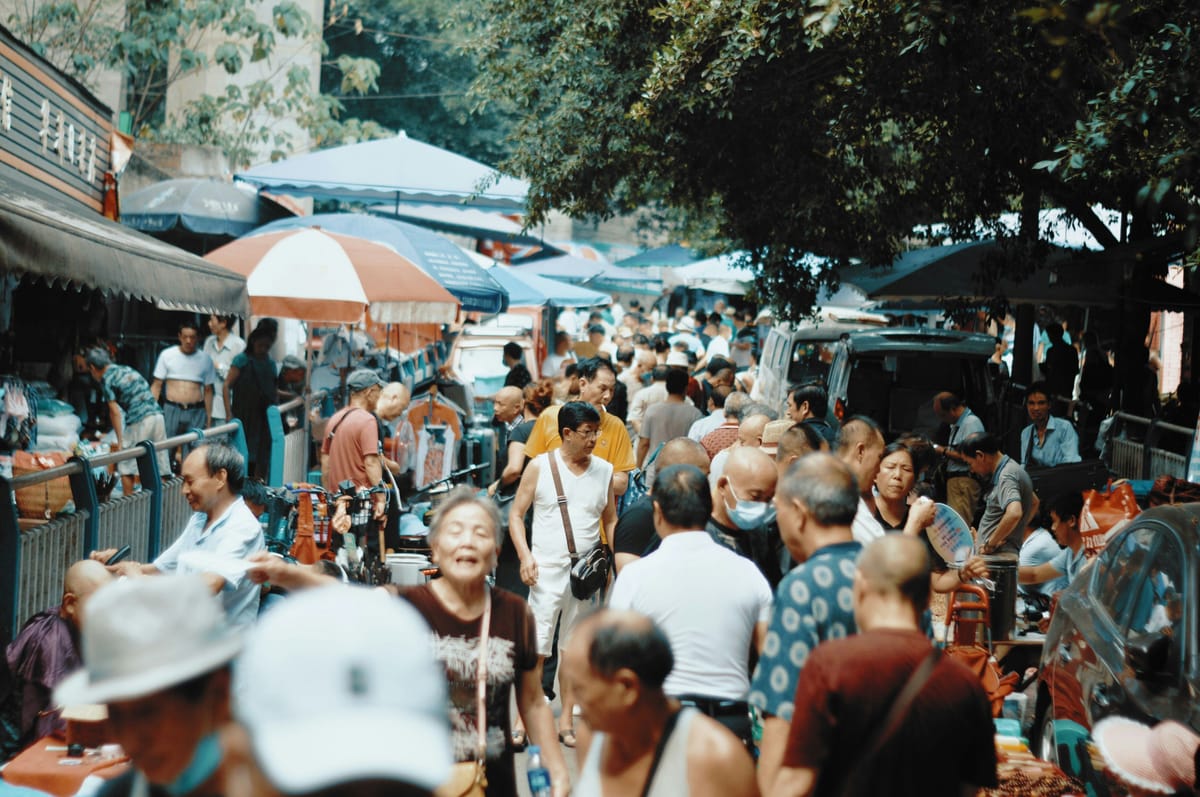 a photograph showing a street market filled with shoppers